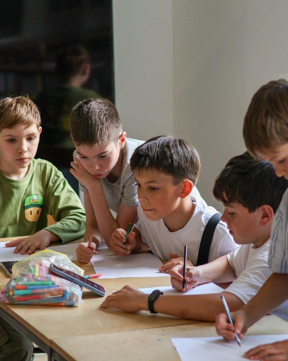 Primary students working together on ideas at a classroom table